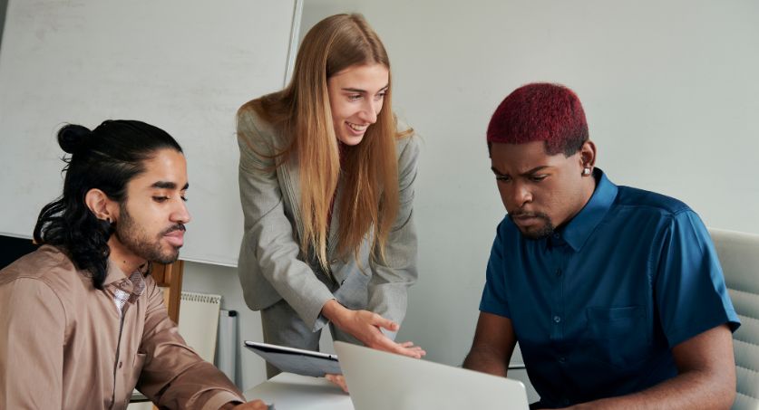 Equipe de marketing de dois homens e uma mulher em u escritório definindo estratégias para conseguir leads